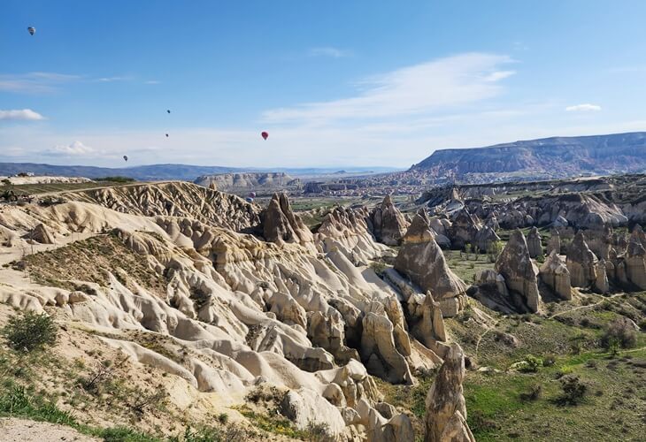 Kapadokya Bağlıdere Vadisi genel görünüm, peri bacaları ve sıcak hava balonları eşliğinde